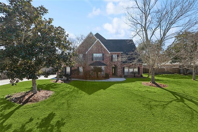 view of front of house featuring brick siding and a front lawn