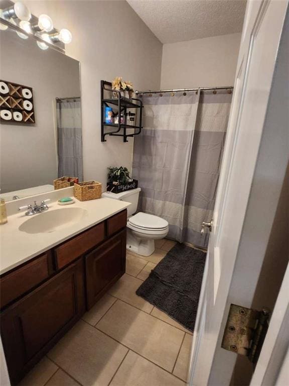 full bathroom featuring vanity, a textured ceiling, toilet, and tile patterned floors