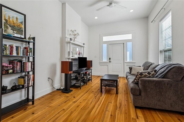 living room with baseboards, recessed lighting, a ceiling fan, and light wood-style floors