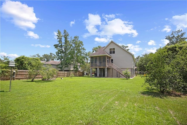 back of house with a yard, a sunroom, fence, and stairway