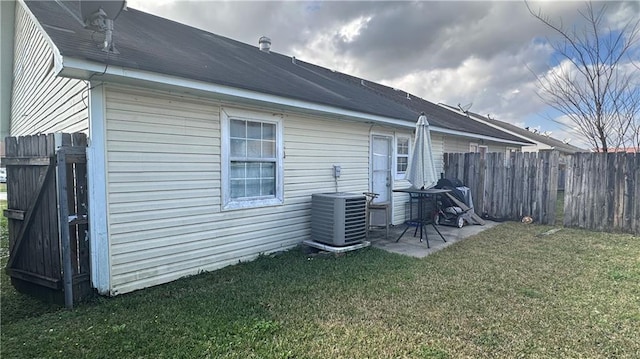 rear view of house with a patio, a lawn, cooling unit, and a fenced backyard