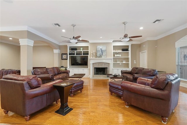 living area featuring ceiling fan, light wood-style flooring, arched walkways, recessed lighting, and ornamental molding