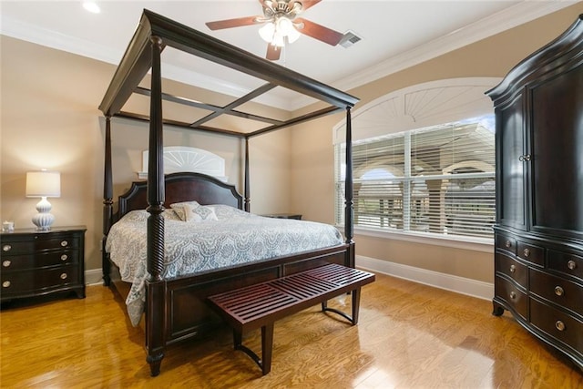 bedroom with light wood-style floors, visible vents, baseboards, and crown molding