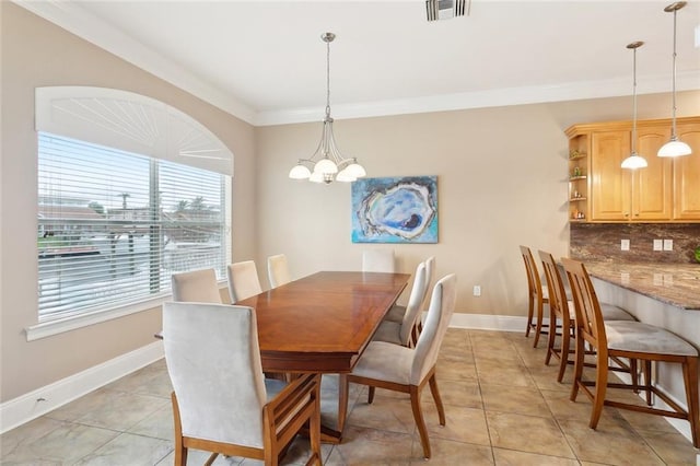 dining space featuring crown molding, a chandelier, baseboards, and light tile patterned flooring