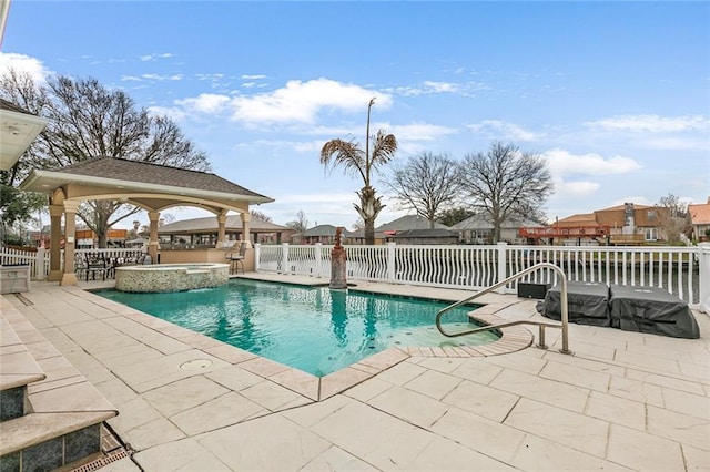 view of swimming pool with a pool with connected hot tub, a patio area, fence, and a gazebo