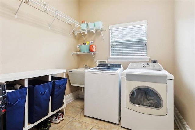 washroom with separate washer and dryer, tile patterned flooring, and baseboards