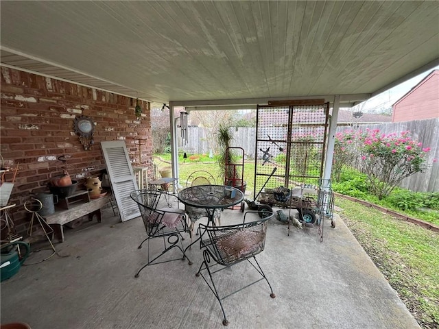 view of patio with outdoor dining space and fence