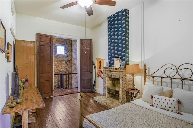 bedroom featuring dark wood-type flooring and a brick fireplace