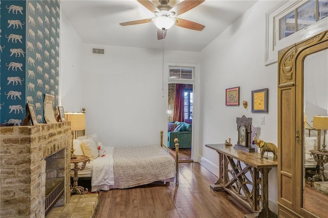 bedroom featuring a ceiling fan, baseboards, visible vents, and wood finished floors