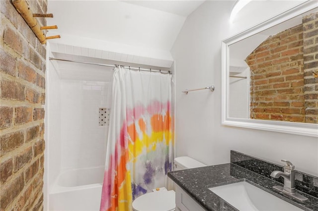 bathroom featuring shower / tub combo with curtain, toilet, vanity, and brick wall