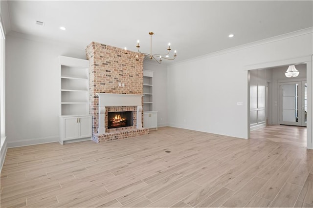 unfurnished living room featuring built in features, light wood-style floors, a chandelier, and crown molding