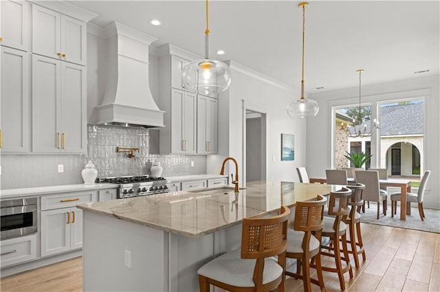 4221 Cypress Point Dr, Covington, LA 70433 - kitchen featuring backsplash, custom exhaust hood, a sink, and light wood finished floors