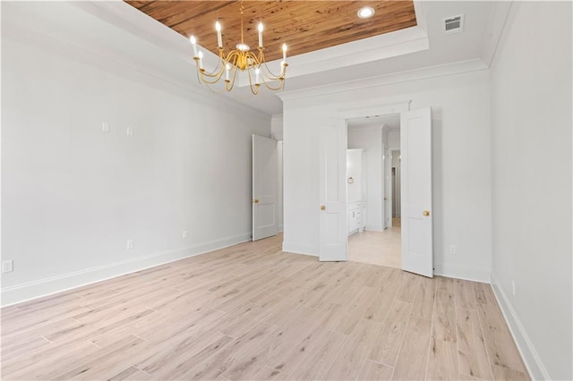 unfurnished room with a raised ceiling, visible vents, an inviting chandelier, light wood-style floors, and wooden ceiling