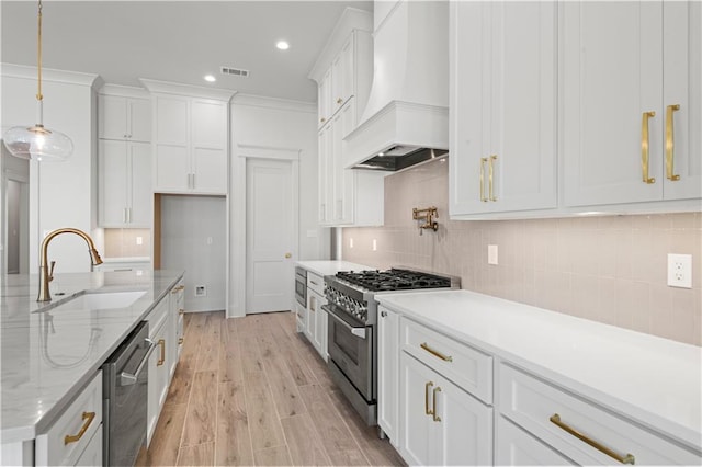4221 Cypress Point Dr, Covington, LA 70433 - kitchen with appliances with stainless steel finishes, a sink, premium range hood, white cabinetry, and visible vents