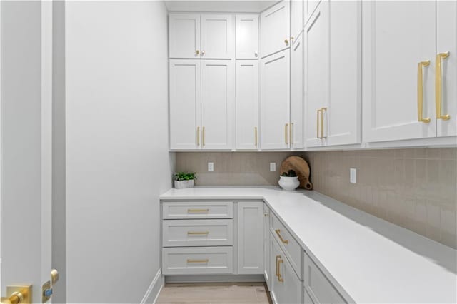 4221 Cypress Point Dr, Covington, LA 70433 - kitchen featuring light countertops, tasteful backsplash, light wood finished floors, and white cabinetry