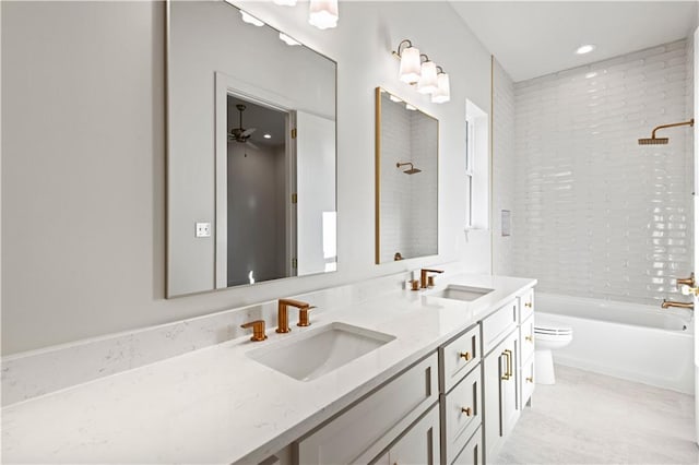 full bath with double vanity, shower / bathing tub combination, a sink, and toilet