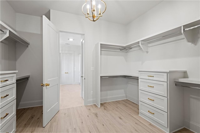 4221 Cypress Point Dr, Covington, LA 70433 - spacious closet featuring an inviting chandelier and light wood-style flooring