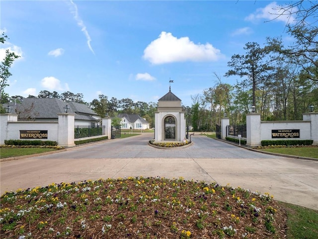 view of road featuring a residential view, curbs, and a gated entry