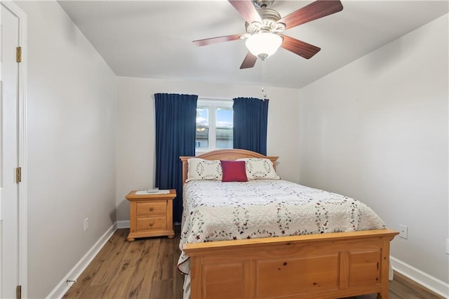 bedroom with ceiling fan, baseboards, and wood finished floors