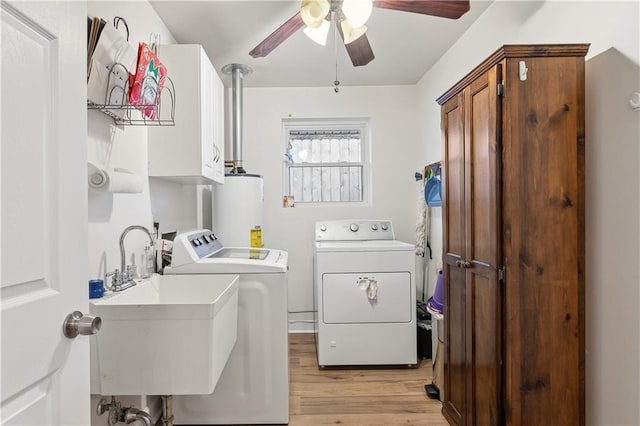 laundry room with cabinet space, washer and clothes dryer, light wood-style flooring, water heater, and a sink