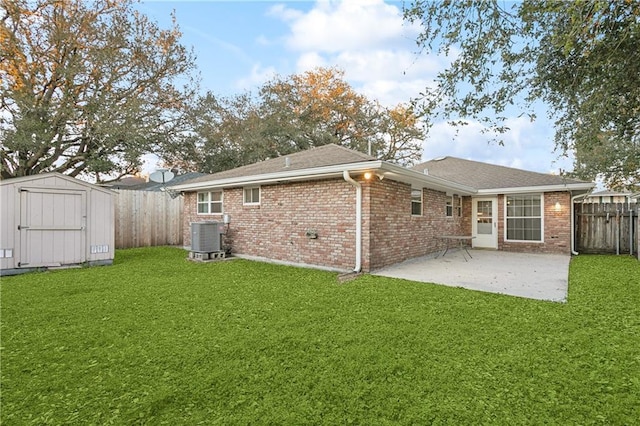 back of house featuring an outbuilding, a patio, a fenced backyard, brick siding, and a shed