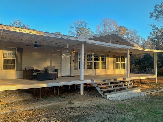 rear view of house featuring a deck, outdoor lounge area, and a ceiling fan