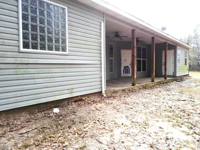 view of side of property featuring a patio area and a ceiling fan