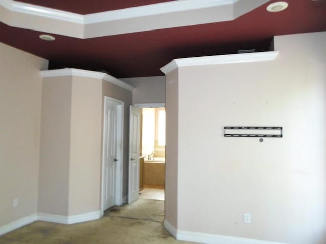 hallway featuring light carpet and baseboards