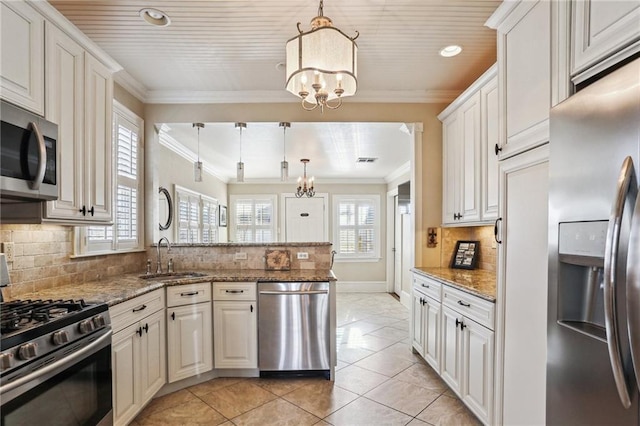 kitchen featuring hanging light fixtures, light stone countertops, white cabinets, and stainless steel appliances