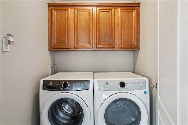 washroom with cabinet space and washer and dryer