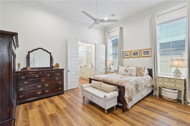 bedroom with ornamental molding, multiple windows, wood finished floors, and visible vents