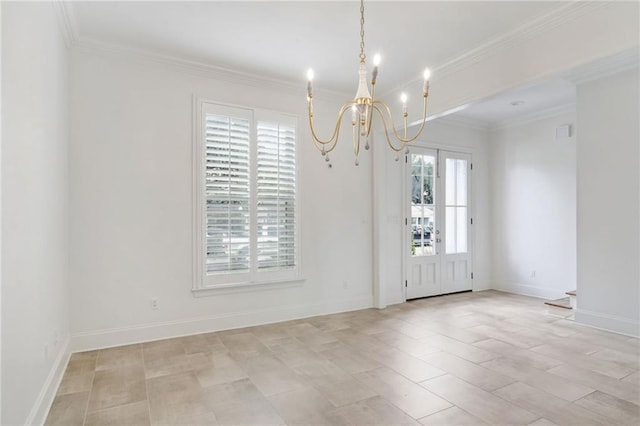 unfurnished room featuring a chandelier, ornamental molding, and baseboards