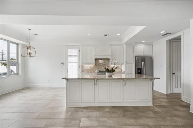 kitchen with a center island, visible vents, appliances with stainless steel finishes, white cabinets, and light stone countertops