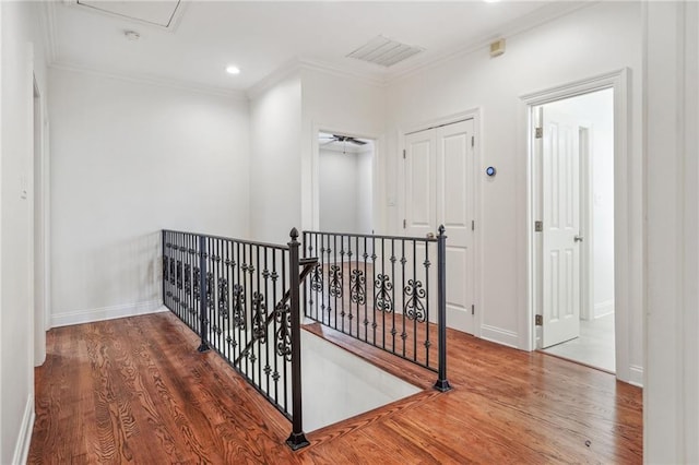 corridor featuring crown molding, recessed lighting, an upstairs landing, wood finished floors, and baseboards