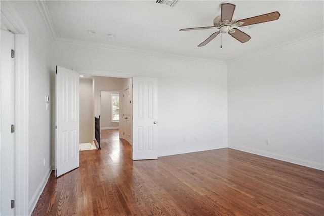 unfurnished room with dark wood finished floors, visible vents, ornamental molding, a ceiling fan, and baseboards