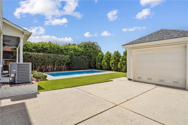 exterior space with central air condition unit, fence, an outdoor pool, and an outbuilding