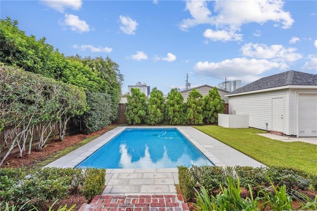 view of swimming pool with a fenced backyard, a fenced in pool, a lawn, and an outdoor structure