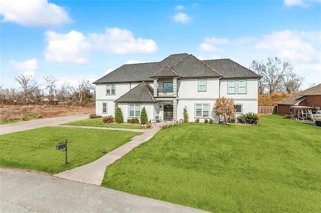 view of front of house featuring a front yard, roof with shingles, and driveway