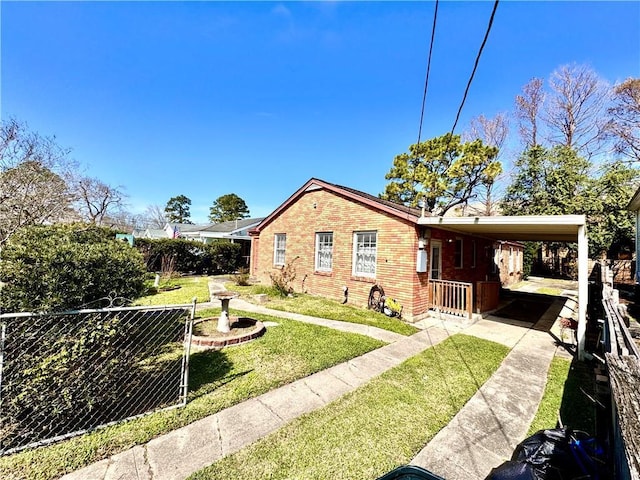 exterior space featuring a carport, brick siding, a lawn, and fence