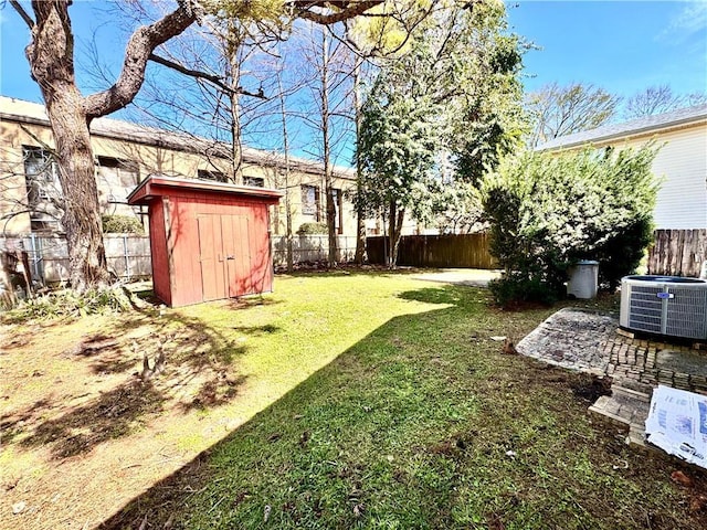 view of yard with an outbuilding, central AC, a storage unit, and a fenced backyard