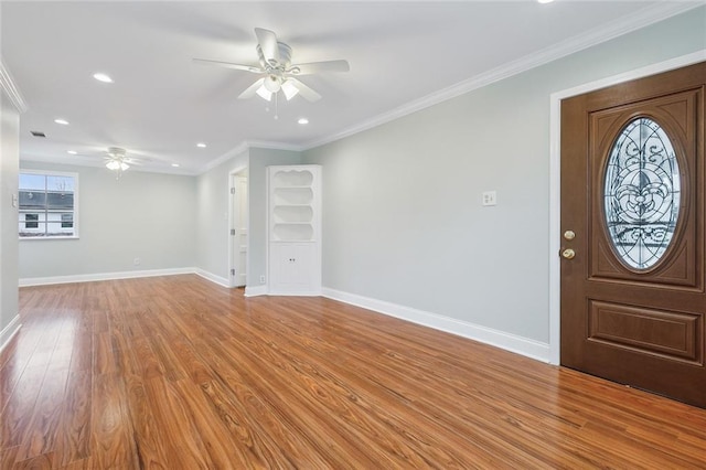 foyer entrance featuring light wood-style floors, ceiling fan, ornamental molding, and baseboards