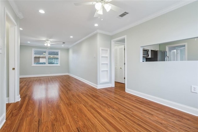 unfurnished room featuring baseboards, visible vents, ceiling fan, light wood-style flooring, and crown molding