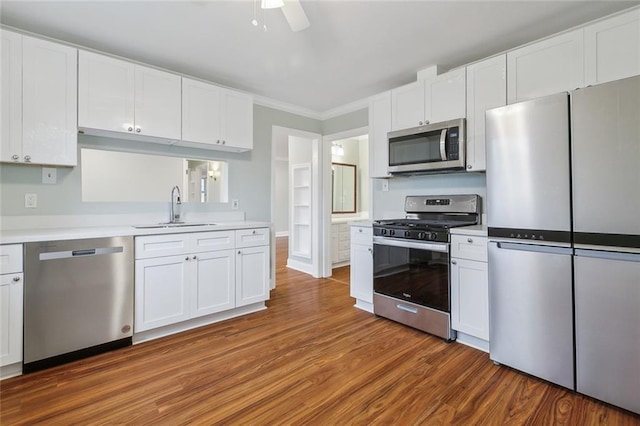 kitchen featuring stainless steel appliances, light countertops, a sink, and white cabinetry