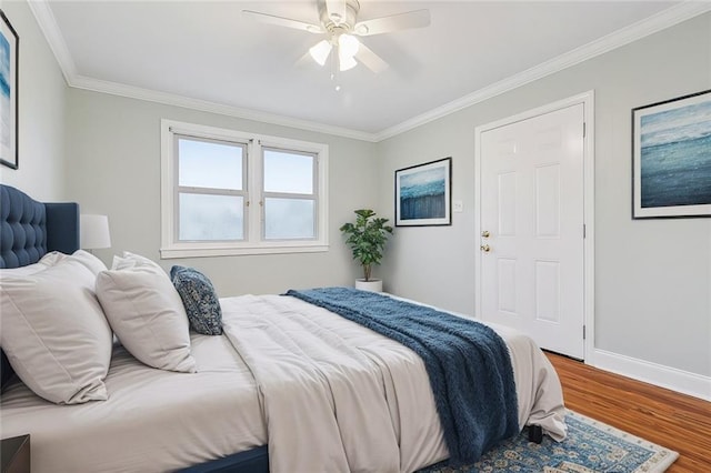 bedroom featuring ceiling fan, ornamental molding, wood finished floors, and baseboards