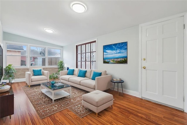 living room with vaulted ceiling, baseboards, and wood finished floors