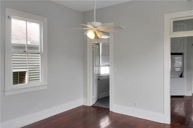 unfurnished room with dark wood-type flooring, plenty of natural light, and baseboards