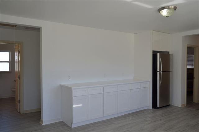 unfurnished room featuring baseboards and light wood finished floors