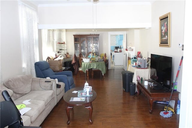 living area with ornamental molding and dark wood-style flooring