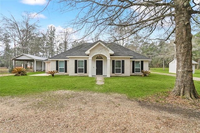 view of front of property with dirt driveway, a front lawn, a shingled roof, and brick siding