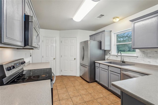 73030 Buds Ln, Covington, LA 70433 - kitchen with appliances with stainless steel finishes, light countertops, a sink, and gray cabinetry